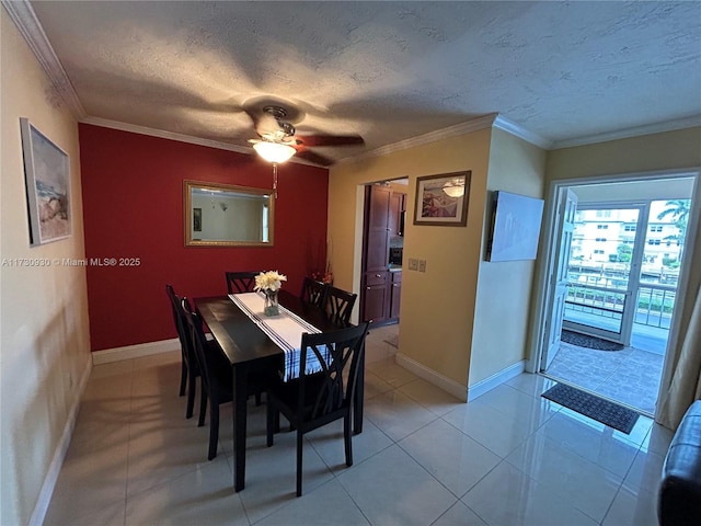 tiled dining area featuring ceiling fan, ornamental molding, and a textured ceiling