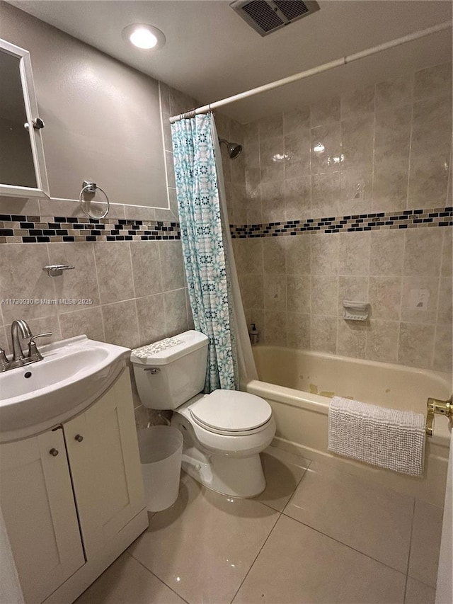 full bathroom with toilet, shower / bath combo with shower curtain, tile walls, tile patterned flooring, and vanity