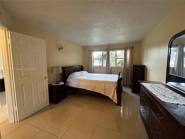 bedroom with a textured ceiling and light tile patterned floors