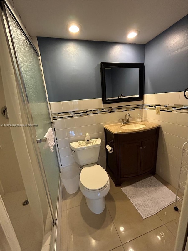 bathroom featuring a shower with door, tile patterned flooring, and tile walls