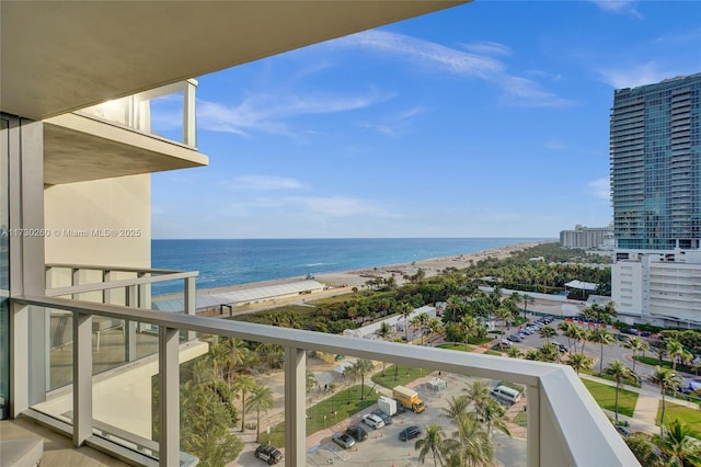 balcony with a water view and a view of the beach