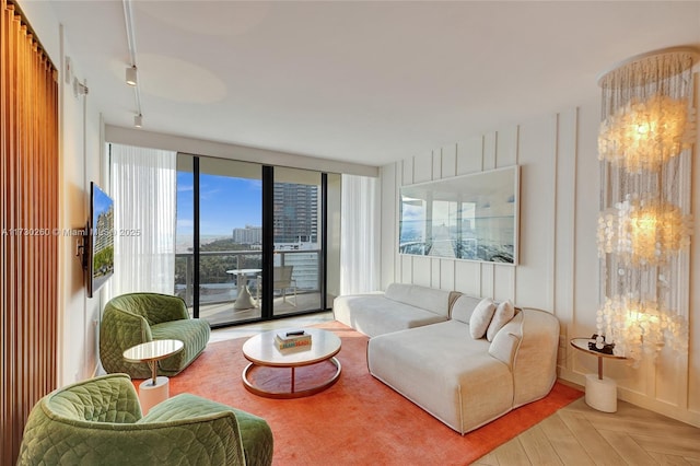 living room with floor to ceiling windows and light parquet flooring