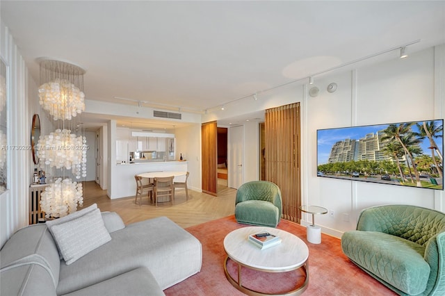 living room with light parquet floors and a notable chandelier