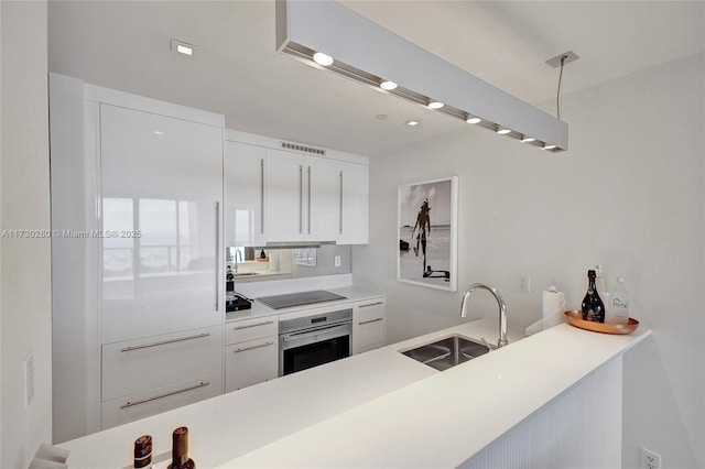 kitchen featuring sink, white cabinets, black electric cooktop, and oven