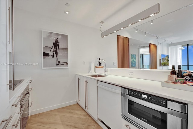 kitchen with light hardwood / wood-style floors, sink, white cabinets, and stainless steel appliances