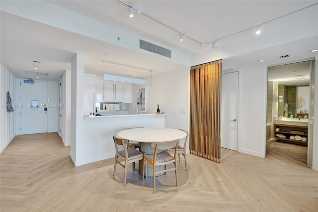 dining space featuring light parquet flooring and sink