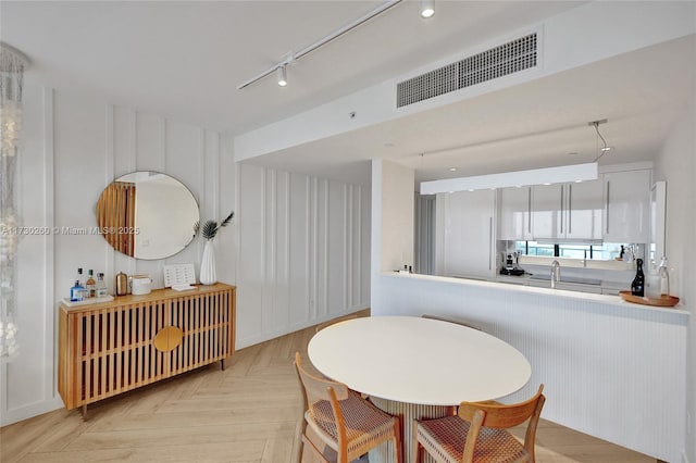 dining area with sink and light parquet flooring