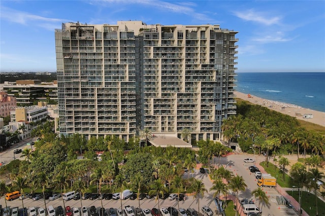 view of building exterior with a beach view and a water view