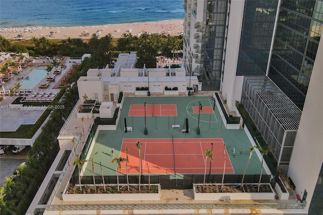 view of basketball court with a water view and a beach view