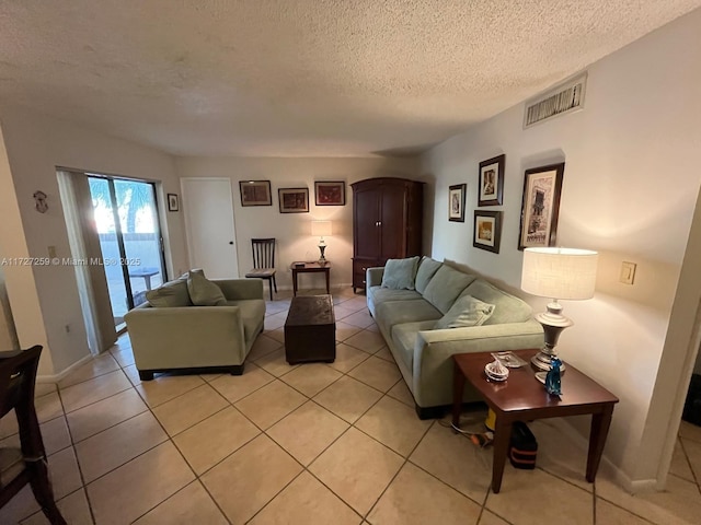 living room with a textured ceiling and light tile patterned floors