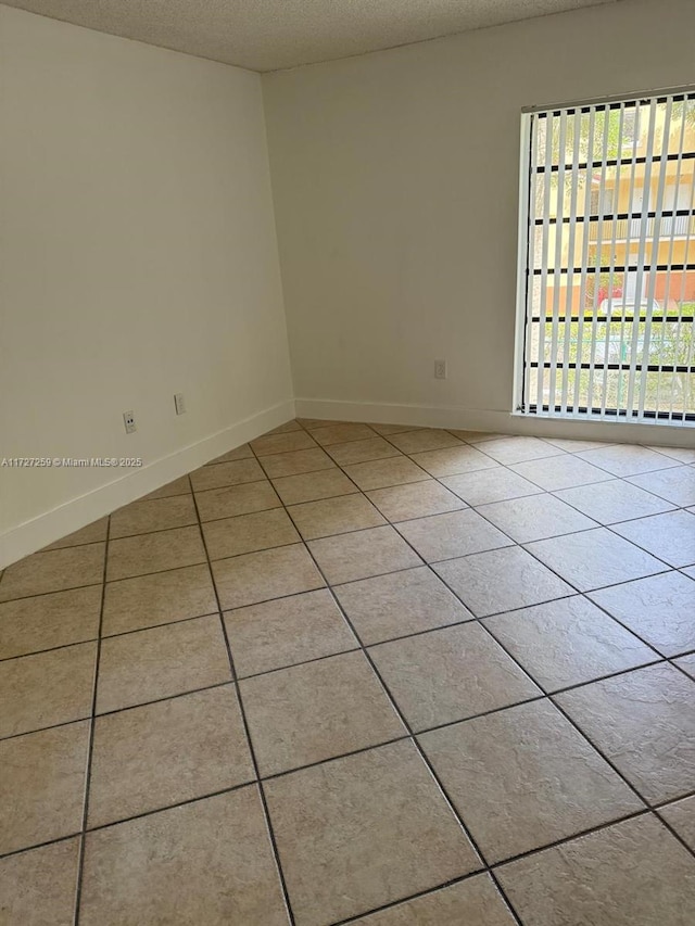 9040 SW 125th Ave Unit D210, Miami, FL 33186 - spare room with light tile patterned flooring, baseboards, and a textured ceiling