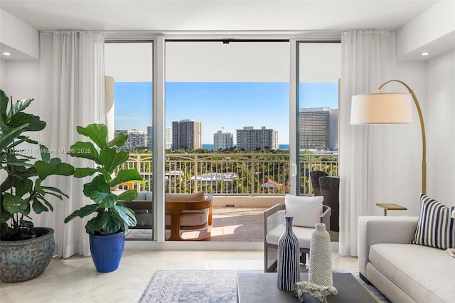 interior space with recessed lighting, marble finish floor, a view of city, and a wall of windows