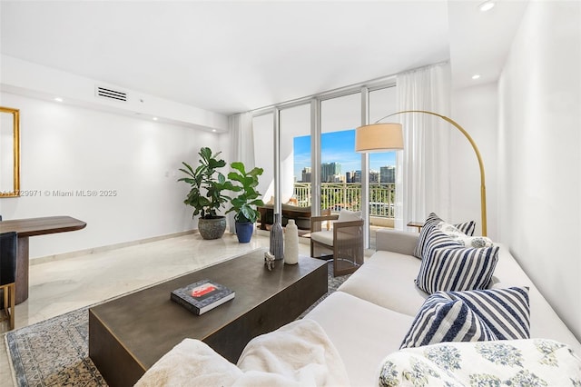 living room with recessed lighting, a city view, visible vents, and expansive windows