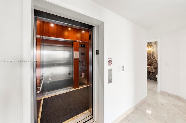 interior space featuring baseboards and elevator