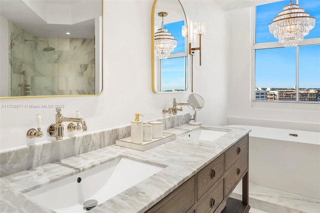 bathroom with vanity, a wealth of natural light, separate shower and tub, and a notable chandelier