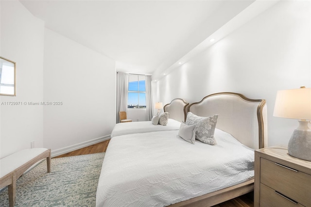 bedroom with wood finished floors and baseboards