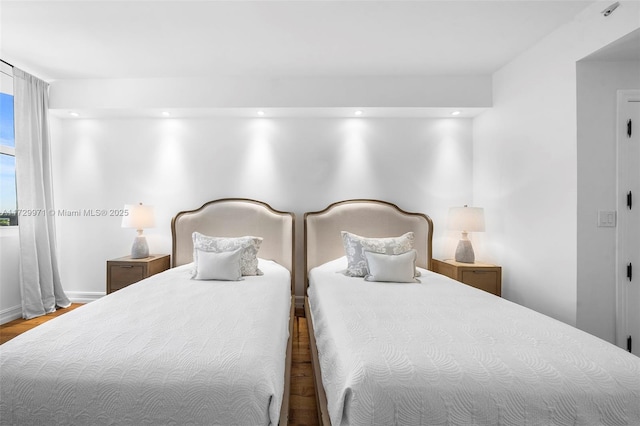 bedroom with baseboards, wood finished floors, and recessed lighting