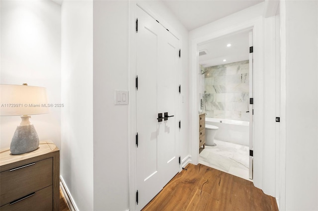 hall featuring recessed lighting, wood finished floors, and baseboards