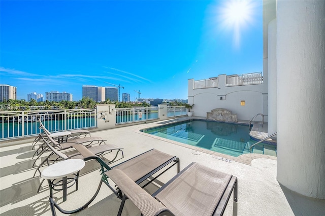 pool with a city view, a patio area, and a water view