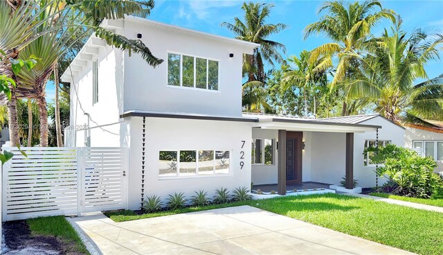 rear view of property with a lawn and a patio