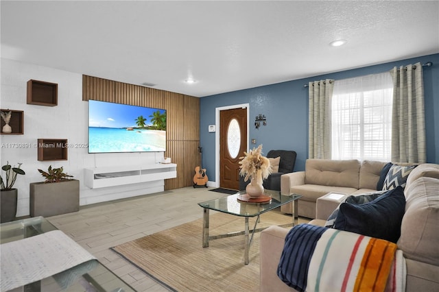 living room with light wood-type flooring and a textured ceiling