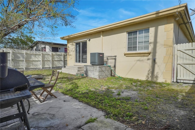 exterior space with a patio area, a yard, and central AC