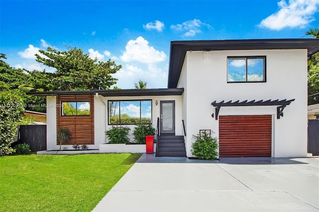 contemporary house featuring a garage and a front lawn