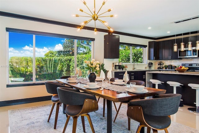 dining area featuring a notable chandelier, baseboards, crown molding, and recessed lighting
