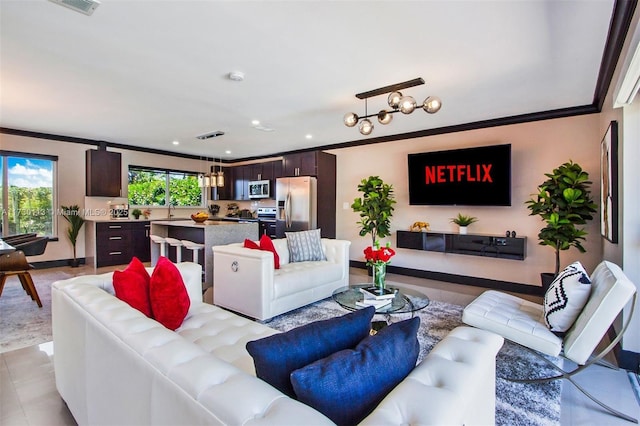 living room featuring baseboards, ornamental molding, and recessed lighting