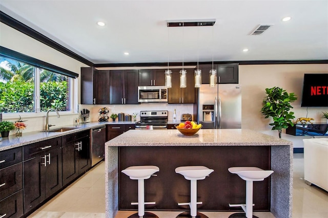 kitchen featuring tasteful backsplash, visible vents, a breakfast bar, stainless steel appliances, and a sink