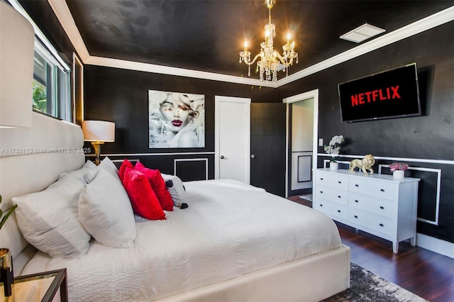 bedroom featuring crown molding, a notable chandelier, and wood finished floors