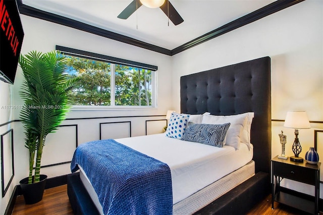bedroom featuring ceiling fan, ornamental molding, and wood finished floors