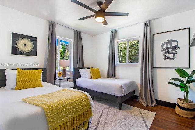 bedroom with wood finished floors, a ceiling fan, and baseboards
