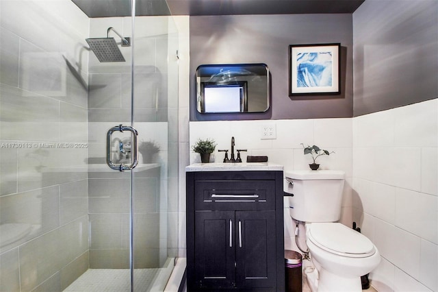 bathroom with a stall shower, toilet, tile walls, and vanity