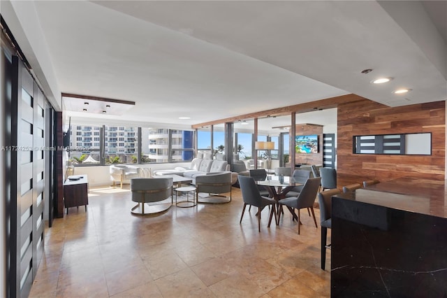 dining room featuring a wealth of natural light and wood walls