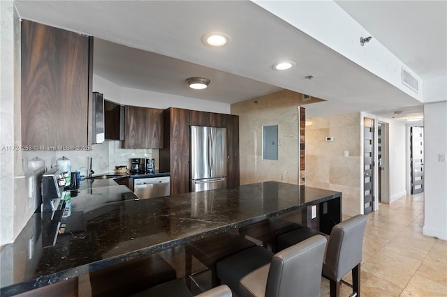 kitchen with sink, a breakfast bar area, stainless steel appliances, and kitchen peninsula