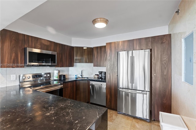 kitchen with appliances with stainless steel finishes, tasteful backsplash, sink, electric panel, and dark brown cabinetry