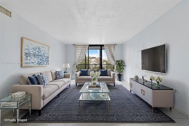 living room with floor to ceiling windows and tile patterned flooring