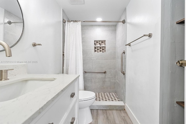 bathroom with hardwood / wood-style floors, vanity, curtained shower, and toilet