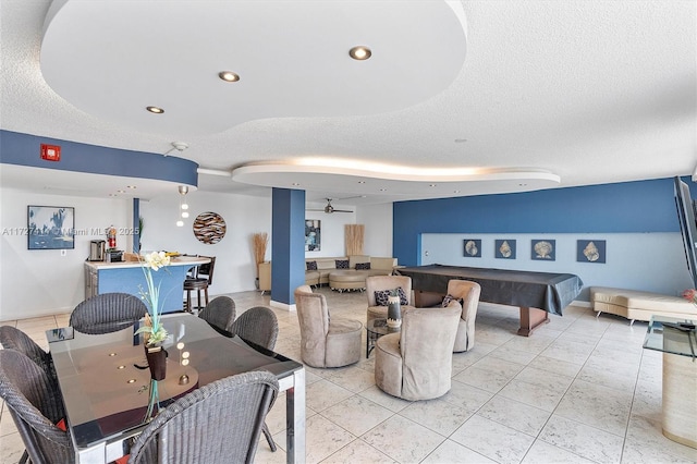 dining area featuring ceiling fan, billiards, and a textured ceiling