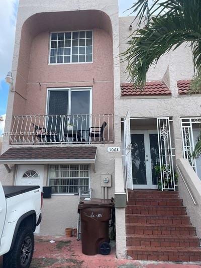 view of front of home with a balcony and french doors