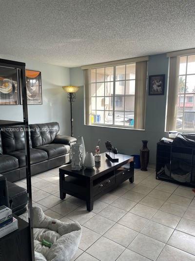 living room featuring light tile patterned floors and a textured ceiling