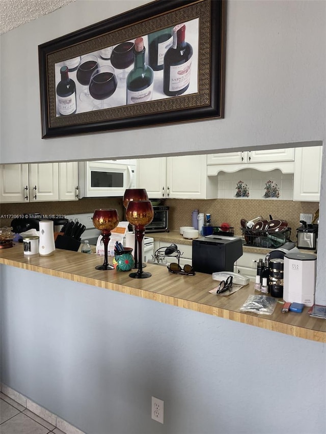 kitchen with light tile patterned floors and tasteful backsplash