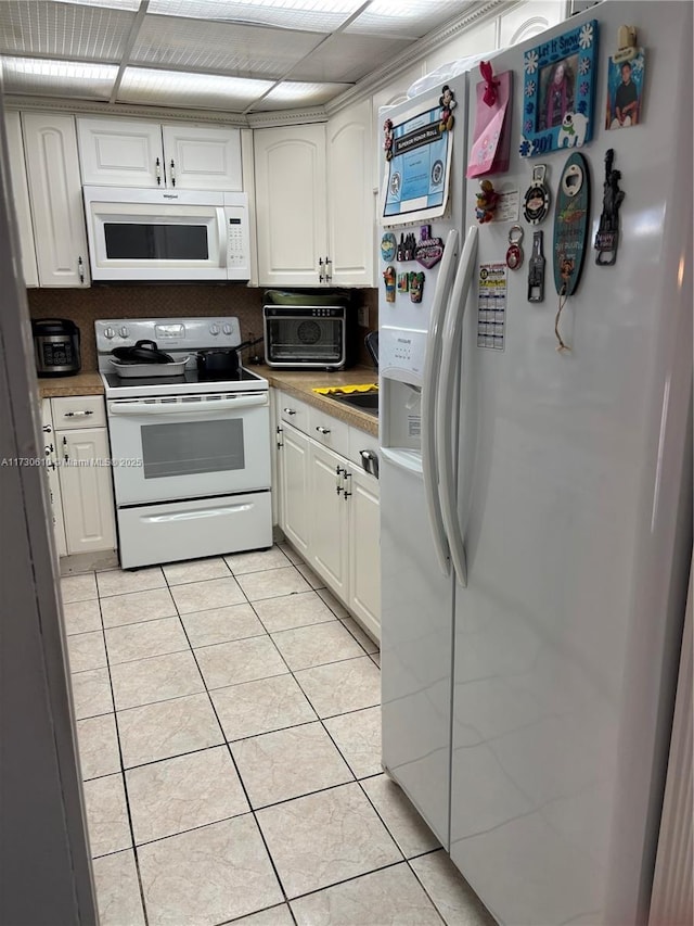 kitchen with white cabinetry, white appliances, and light tile patterned floors