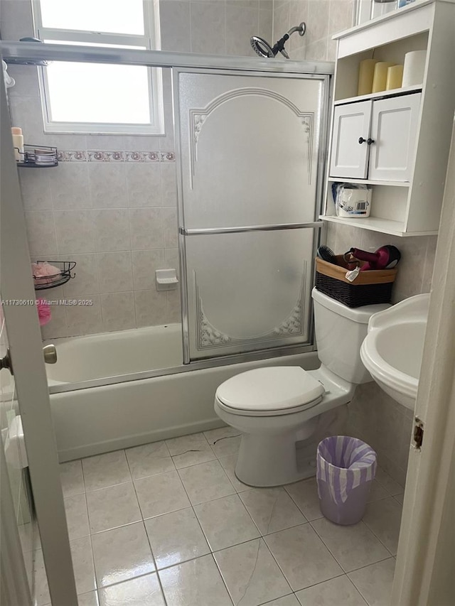 full bathroom featuring toilet, enclosed tub / shower combo, sink, and tile patterned flooring