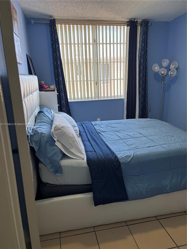 bedroom featuring tile patterned flooring and a textured ceiling