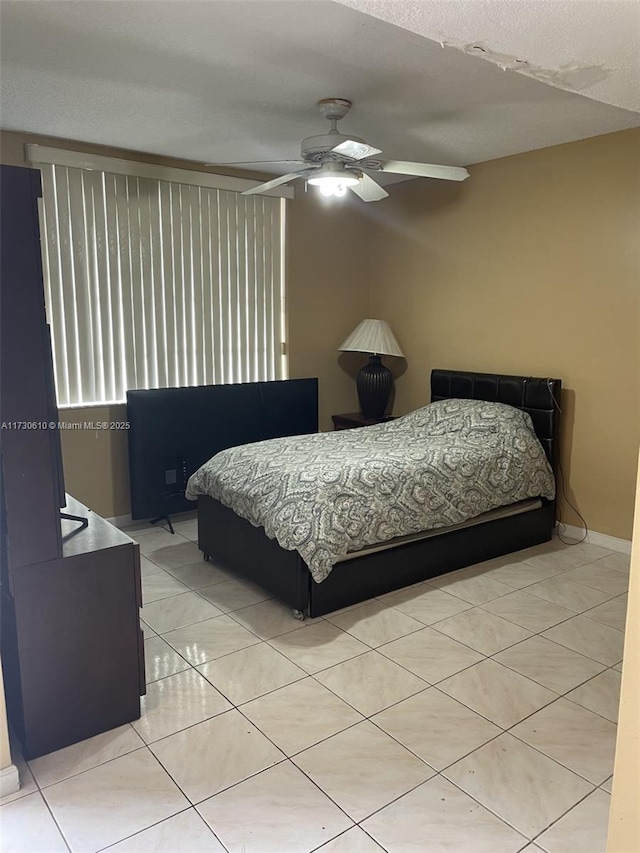 bedroom with ceiling fan and light tile patterned floors