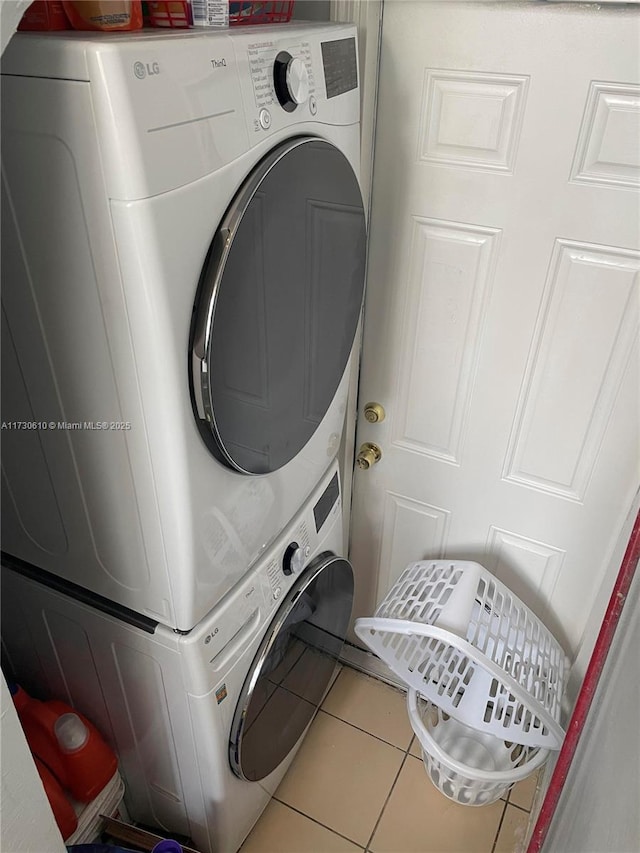 laundry area featuring stacked washer and dryer and tile patterned floors