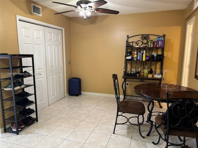 dining area with light tile patterned floors, a textured ceiling, and ceiling fan