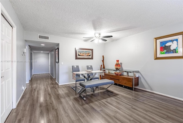 interior space with ceiling fan, a textured ceiling, and hardwood / wood-style floors